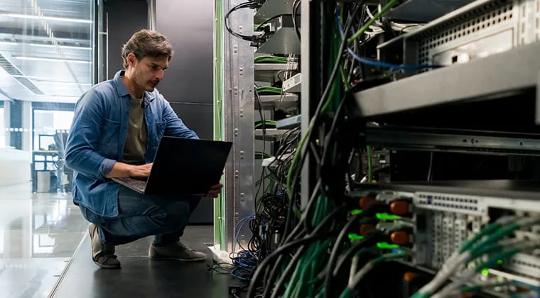 Person with dedicated ethernet using a laptop in a data center