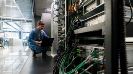 person kneeling in a data center