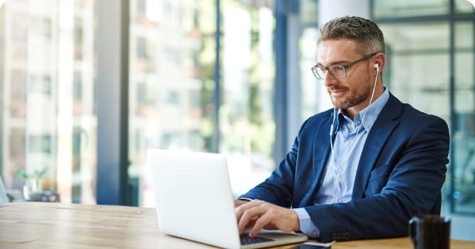 Person wearing ear buds working on a laptop