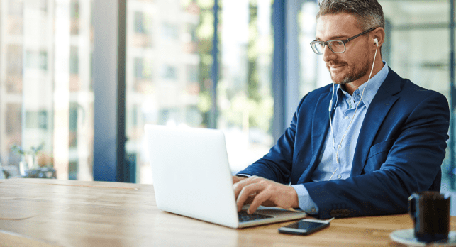 a person is wearing a navy suit and working on a laptop