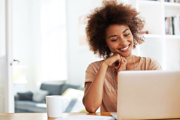 Person smiling in front of laptop