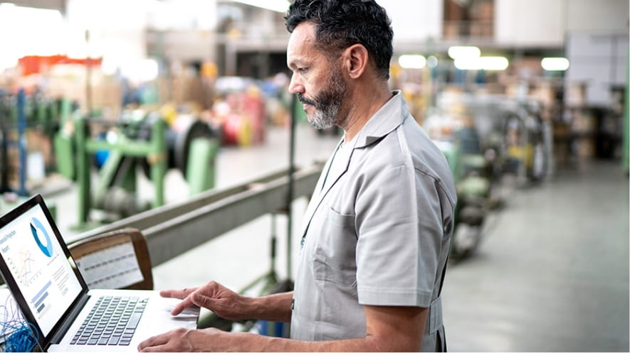 Person using a laptop in a warehouse
