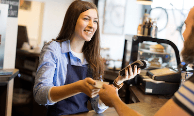 person is working in a cafe with a blue apron